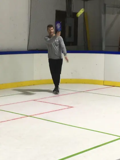 A player swinging a paddle on the court